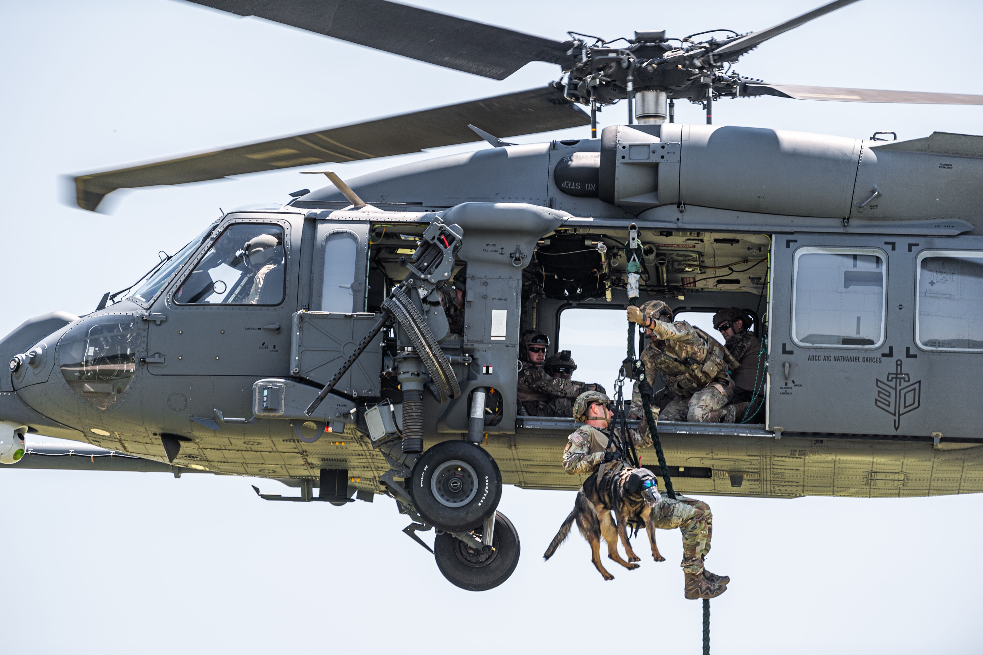 A 45th Security Forces Squadron military working dog handler and K9 conduct fast rope insertion and extraction system training from an HH-60W Jolly Green II helicopter at Moody Air Force Base, Ga., June 28, 2023