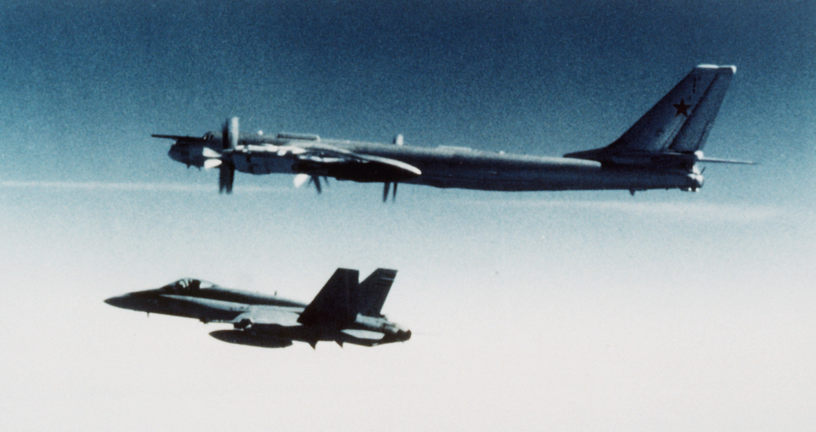 Vista aria-aria del lato sinistro di un bombardiere sovietico Bear H accanto a un CF-18 Hornet canadese - DPLA - 618f