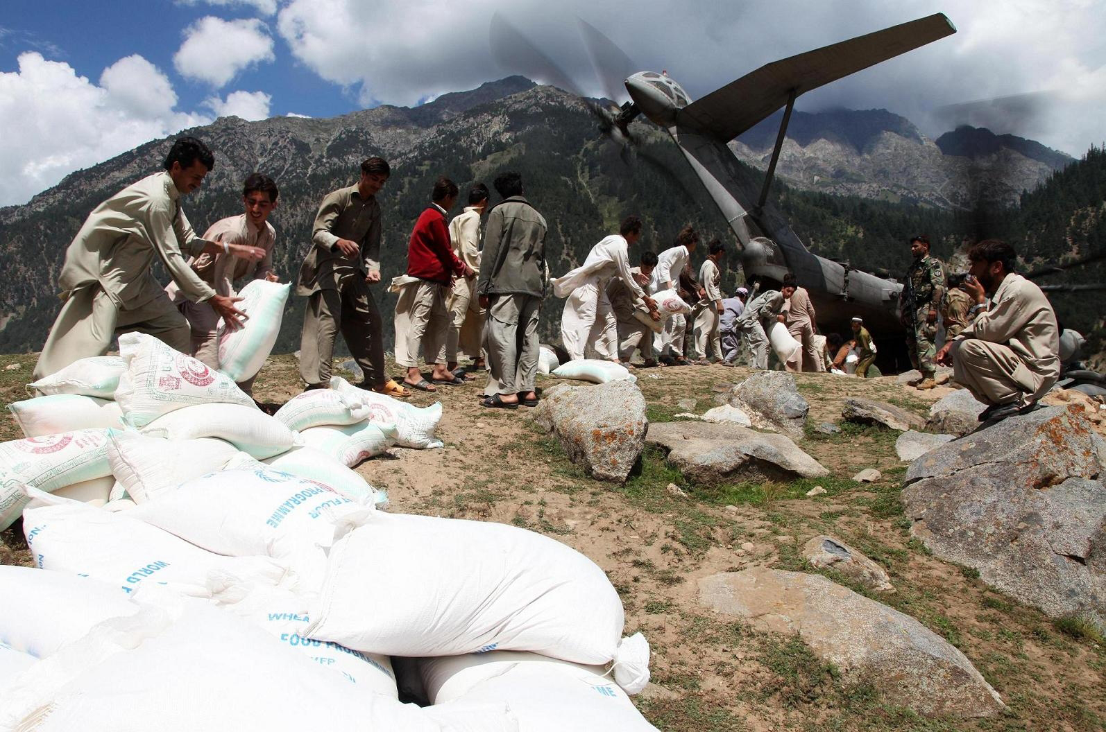 Defense gov News Photo 100908 F-999K-222 - Uomini del posto aiutano i Marines statunitensi a scaricare centinaia di sacchi di farina da un aereo KC-130J Super Hercules alla base aerea di Gilgit, Pakistan, a sett