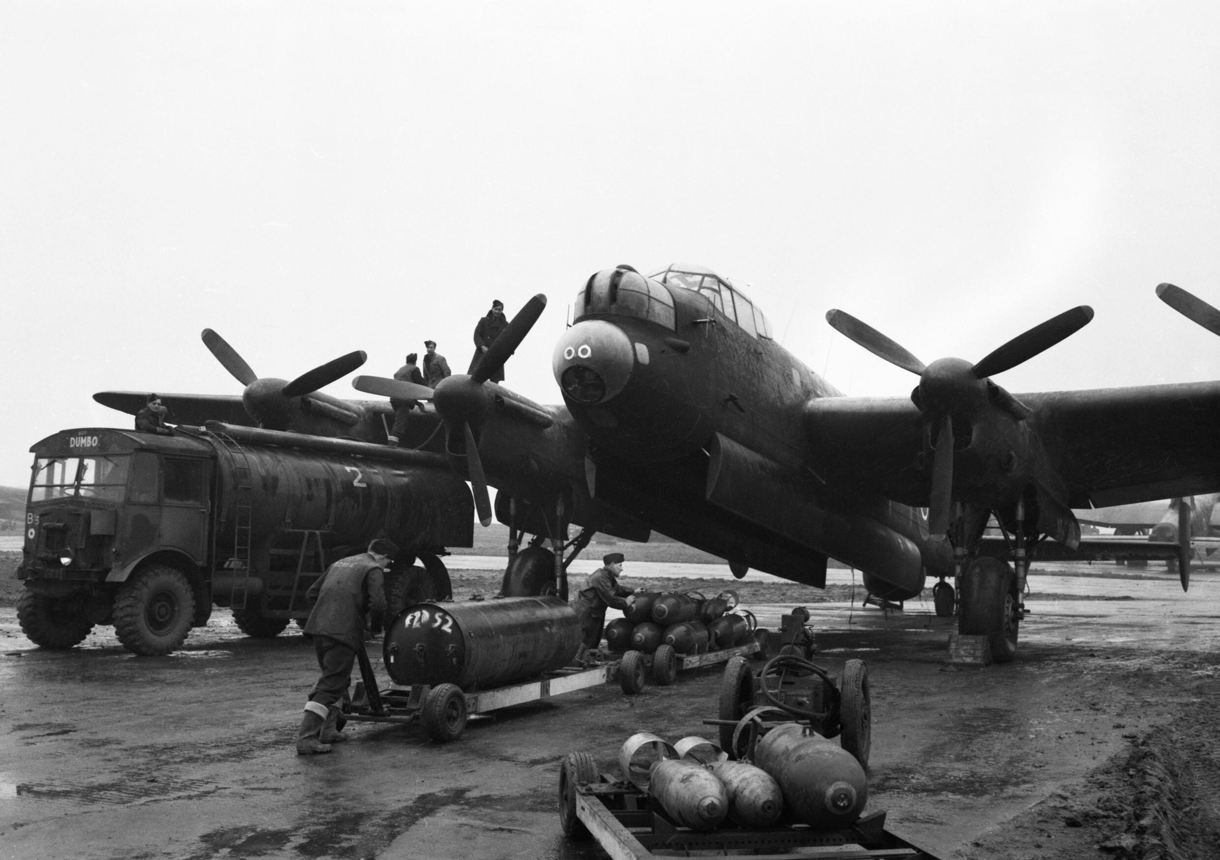 Bodenpersonal betankt eine Lancaster der No. 75 New Zealand Squadron in Mepal und belädt sie mit Bomben