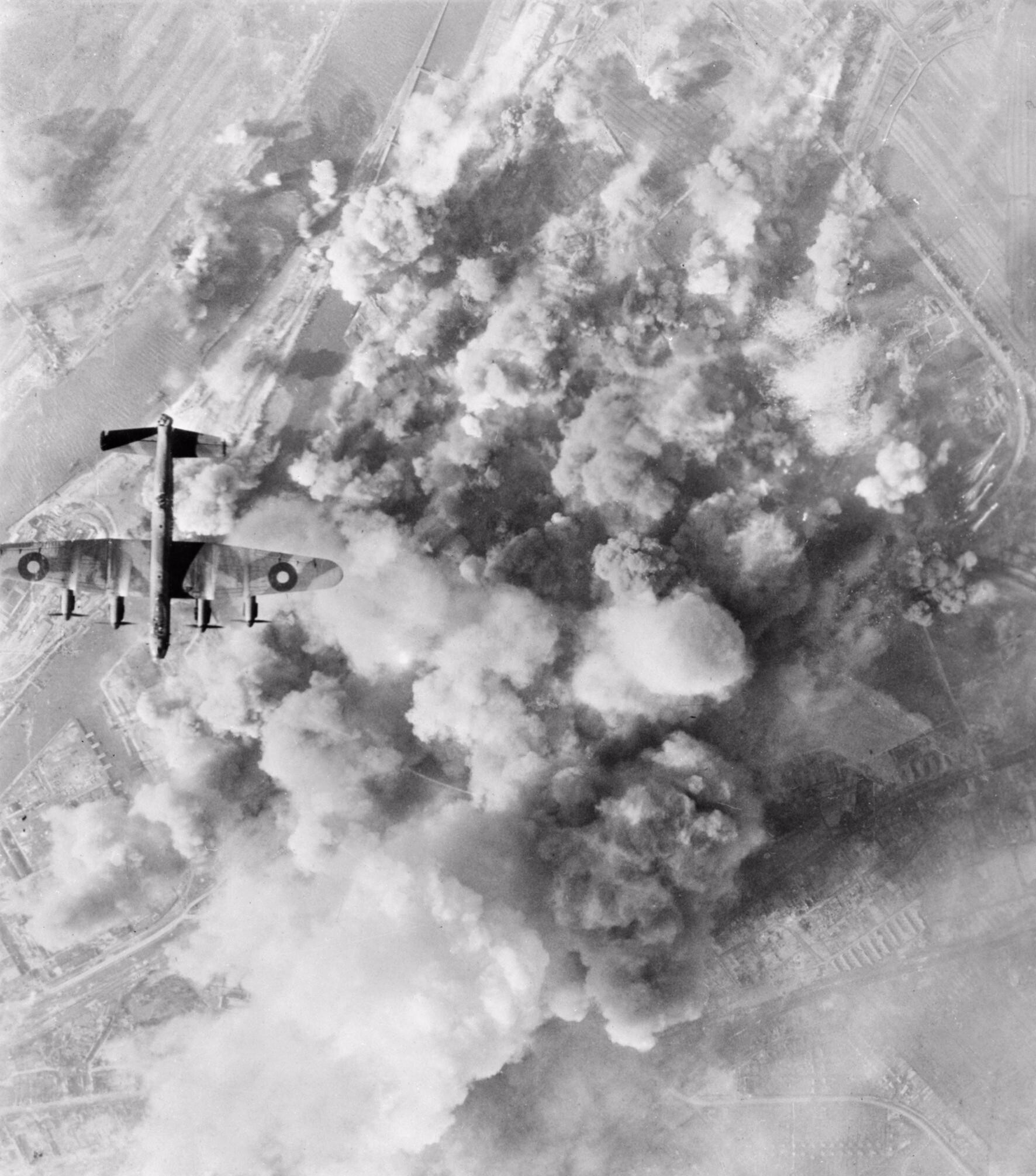 Lancaster of No. 300 Polish Squadron over the smoke covered oil refinery at Bremen, March 1945