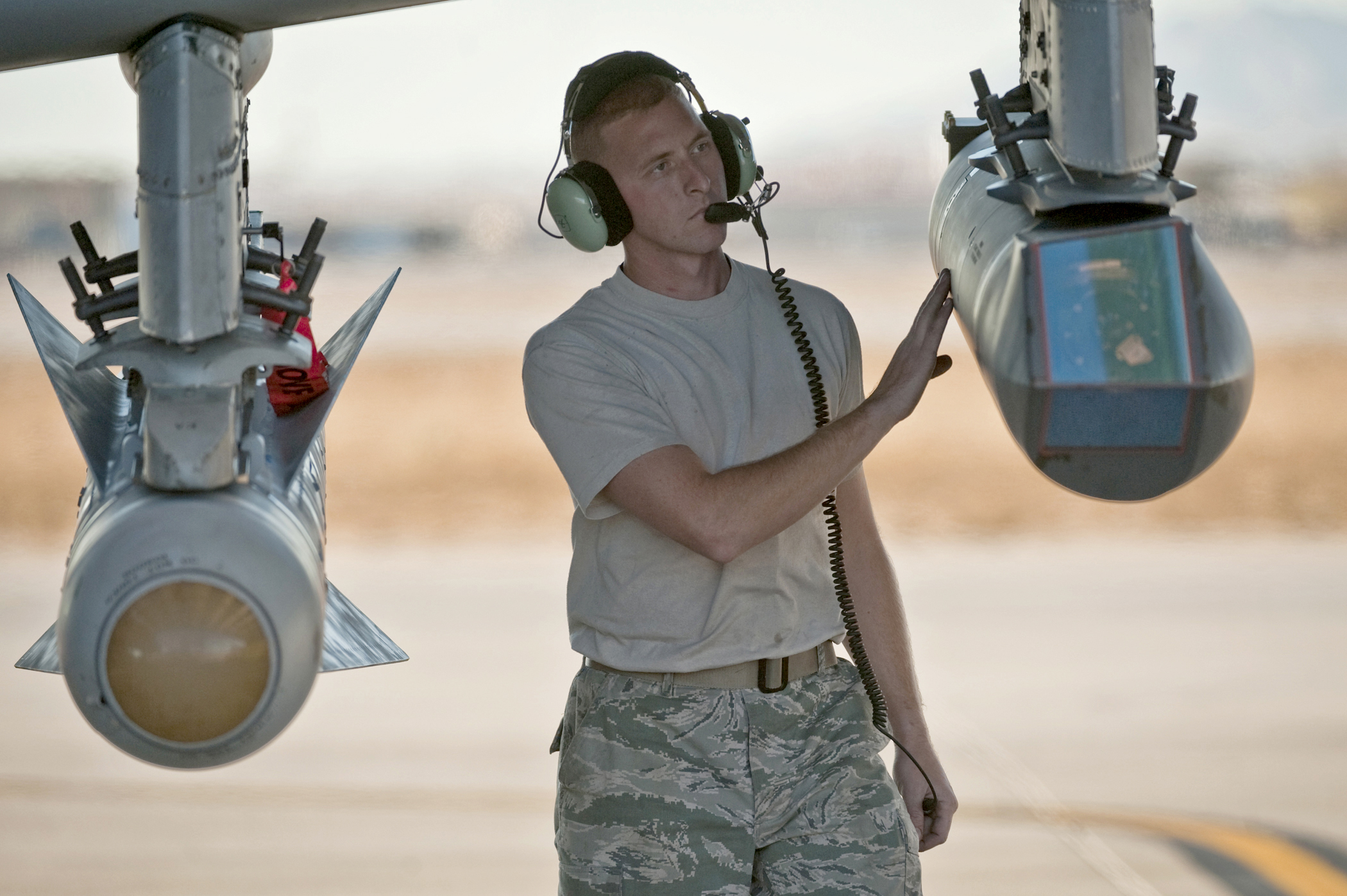 Personal de mantenimiento revisa un pod de designación de blancos montado en un A-10 Thunderbolt II