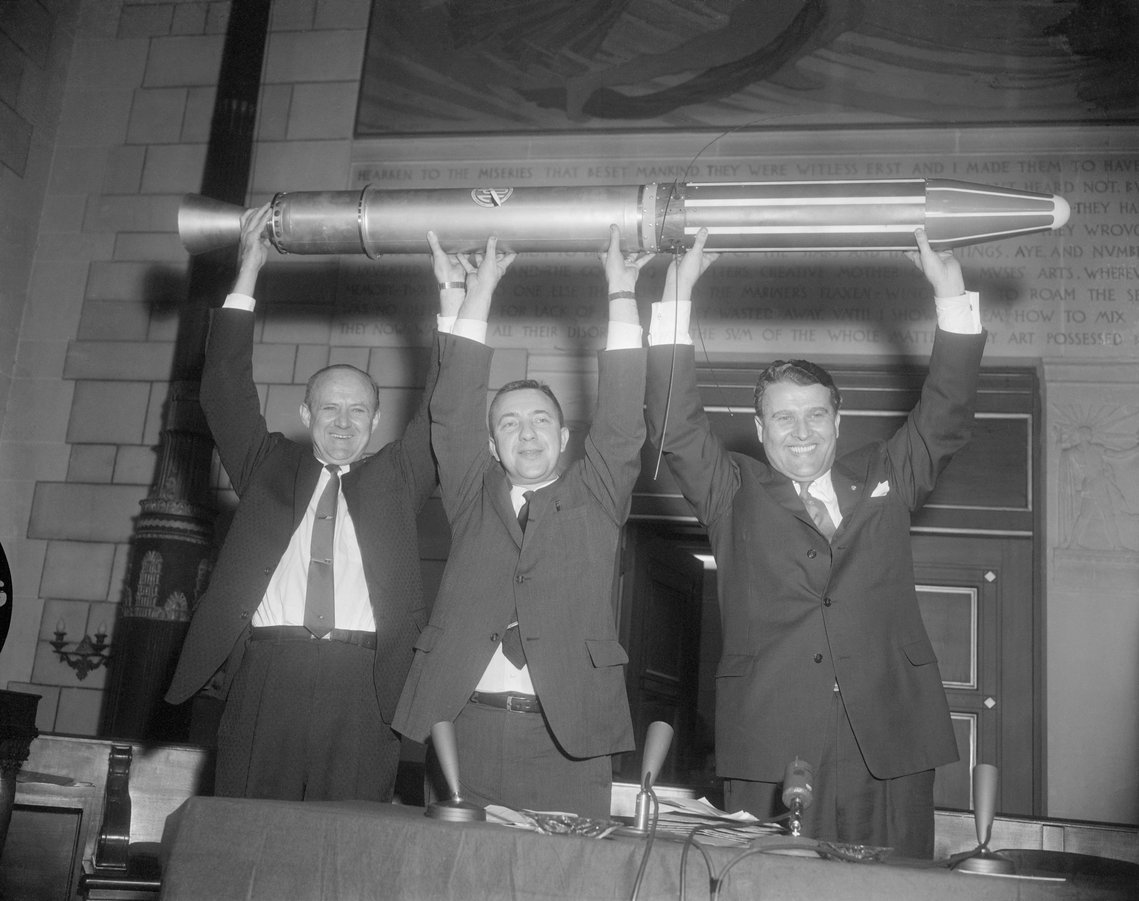 Pickering, Van Allen and von Braun hold up a model of Explorer 1 after the Juno I launch