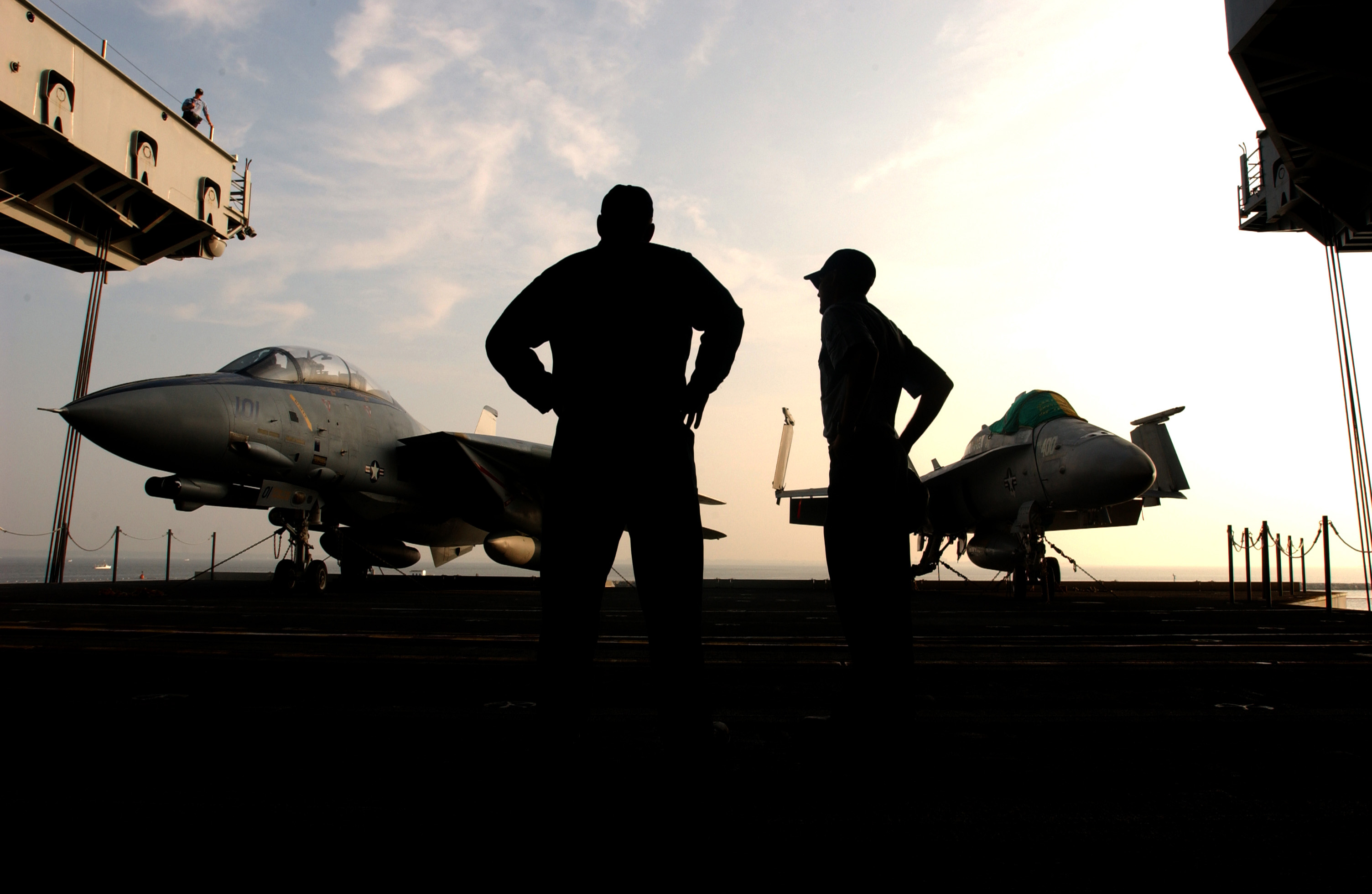 US Navy 030709 N-0696M 015 Matrosen bereiten sich darauf vor, einen F-14 Tomcat und eine F/A-18 Hornet mit einem der Flugzeugaufzüge des Schiffs auf das Flugdeck zu heben, um sie während der Zeremonie als statische Ausstellungsstücke auf dem Flugdeck zu zeigen