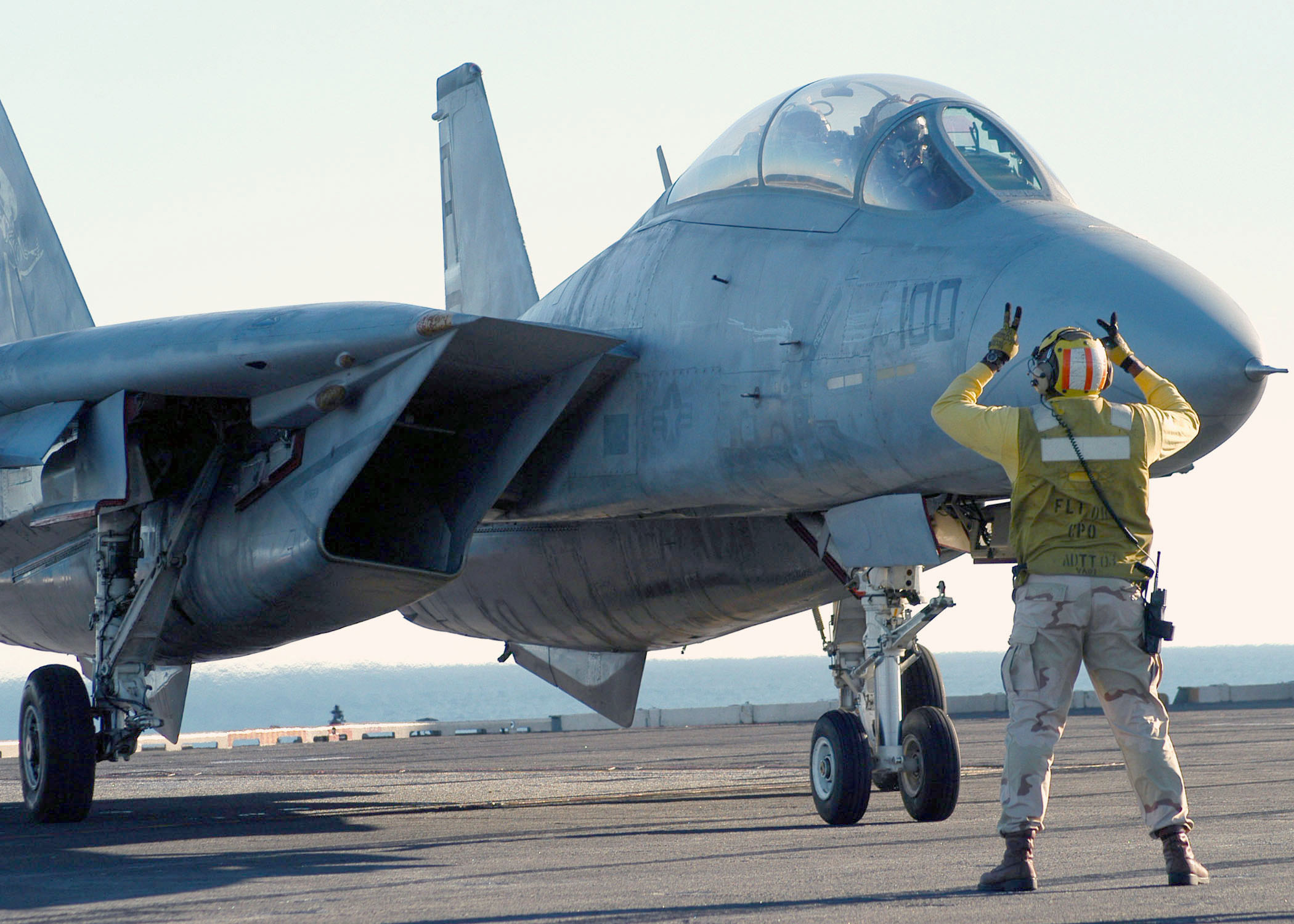 US Navy 031101 N-2838C 501 El suboficial jefe de aviación Wilson Theodore dirige un F-14, asignado a los Grim Reapers del Fighter Squadron One Zero One (VF-101), hasta su posición en la cubierta de vuelo a bordo del USS Theodore Roosevelt