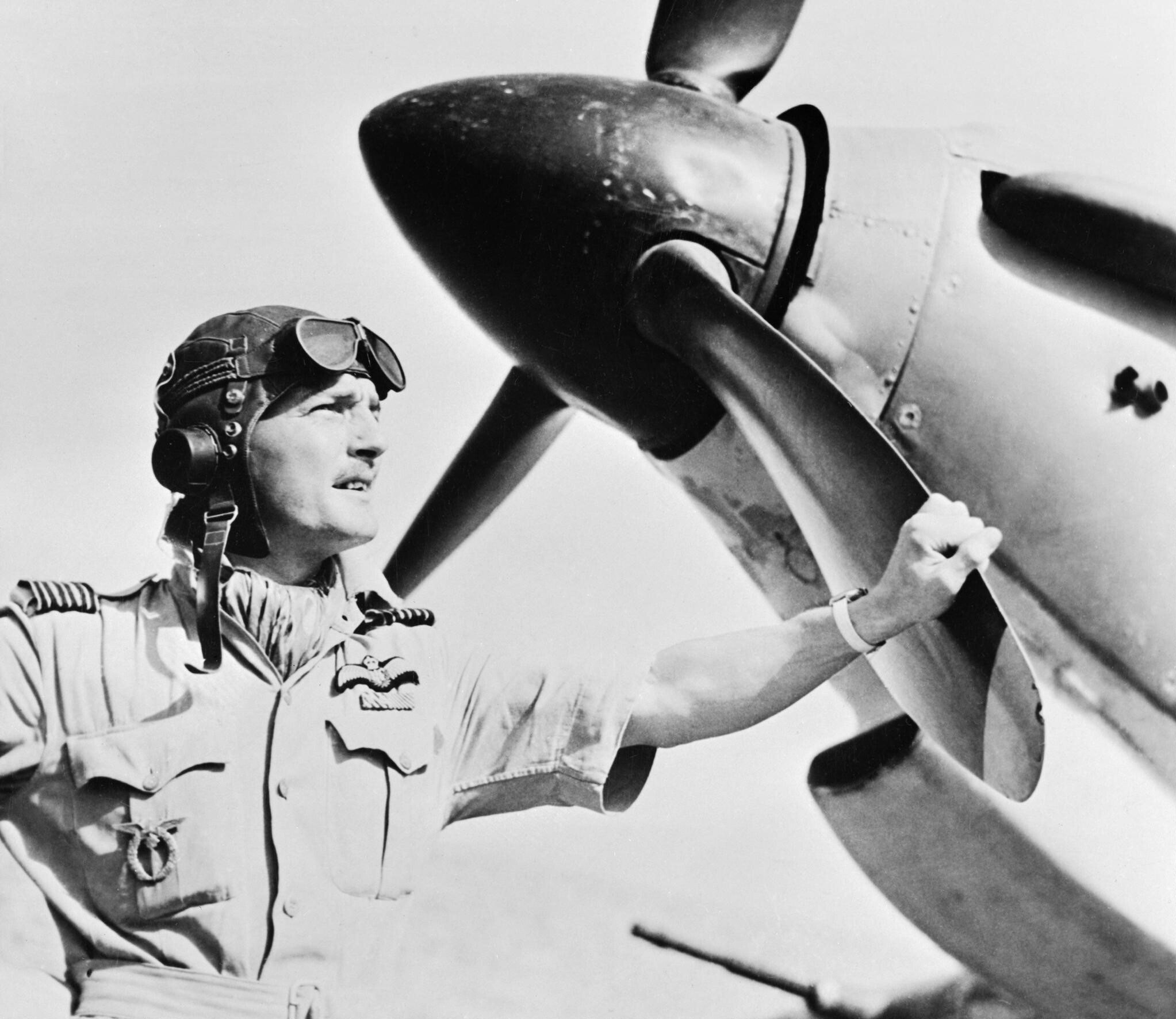 Wing Commander Frank Carey, Officer Commanding the Air Firing Training Unit, based at Amarda Road, India, standing by the nose of a Hawker Hurricane, April 1943. CI171