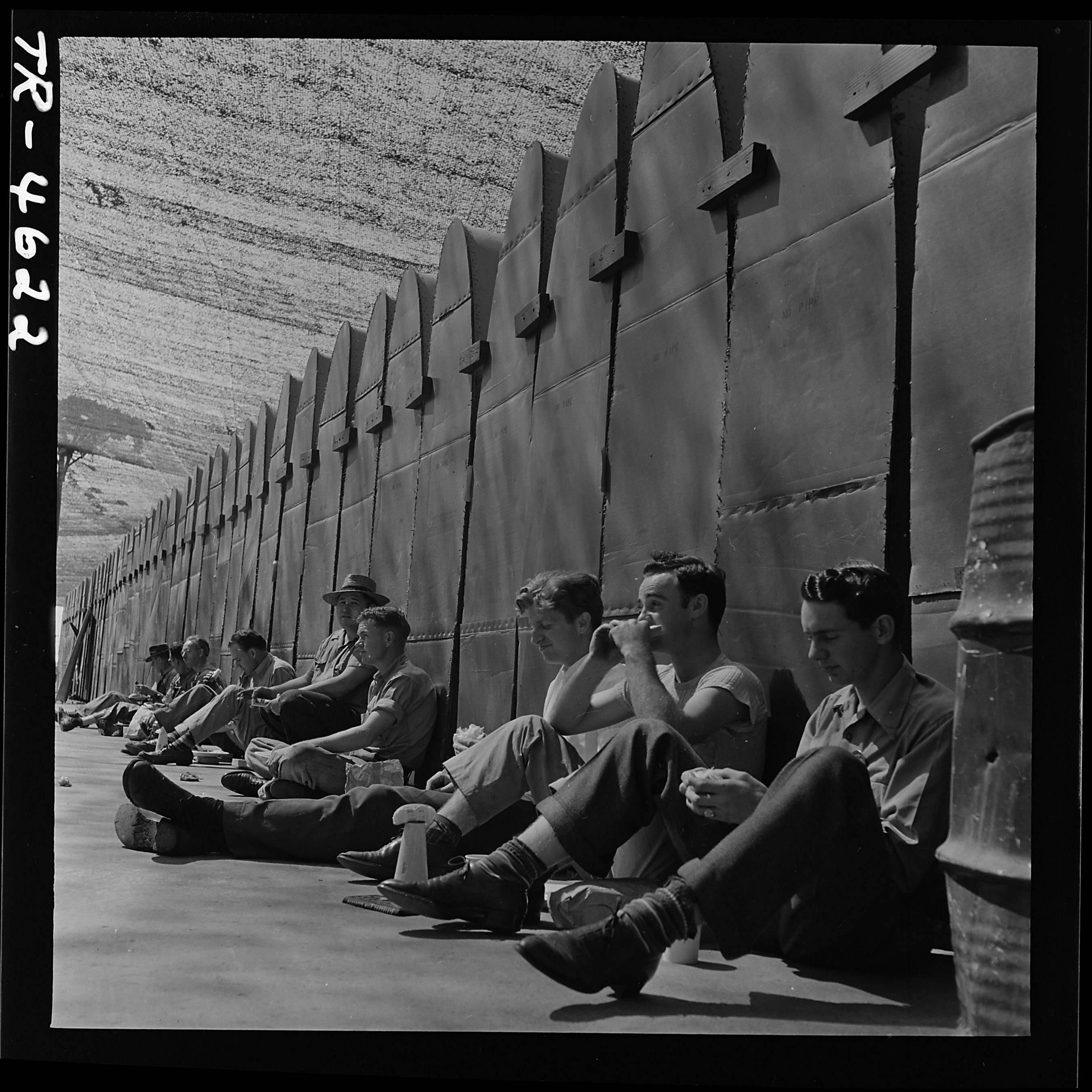 Workers eat lunch against PBY wing panels at Consolidated Vultee aircraft plant, San Diego, Cal. - NARA