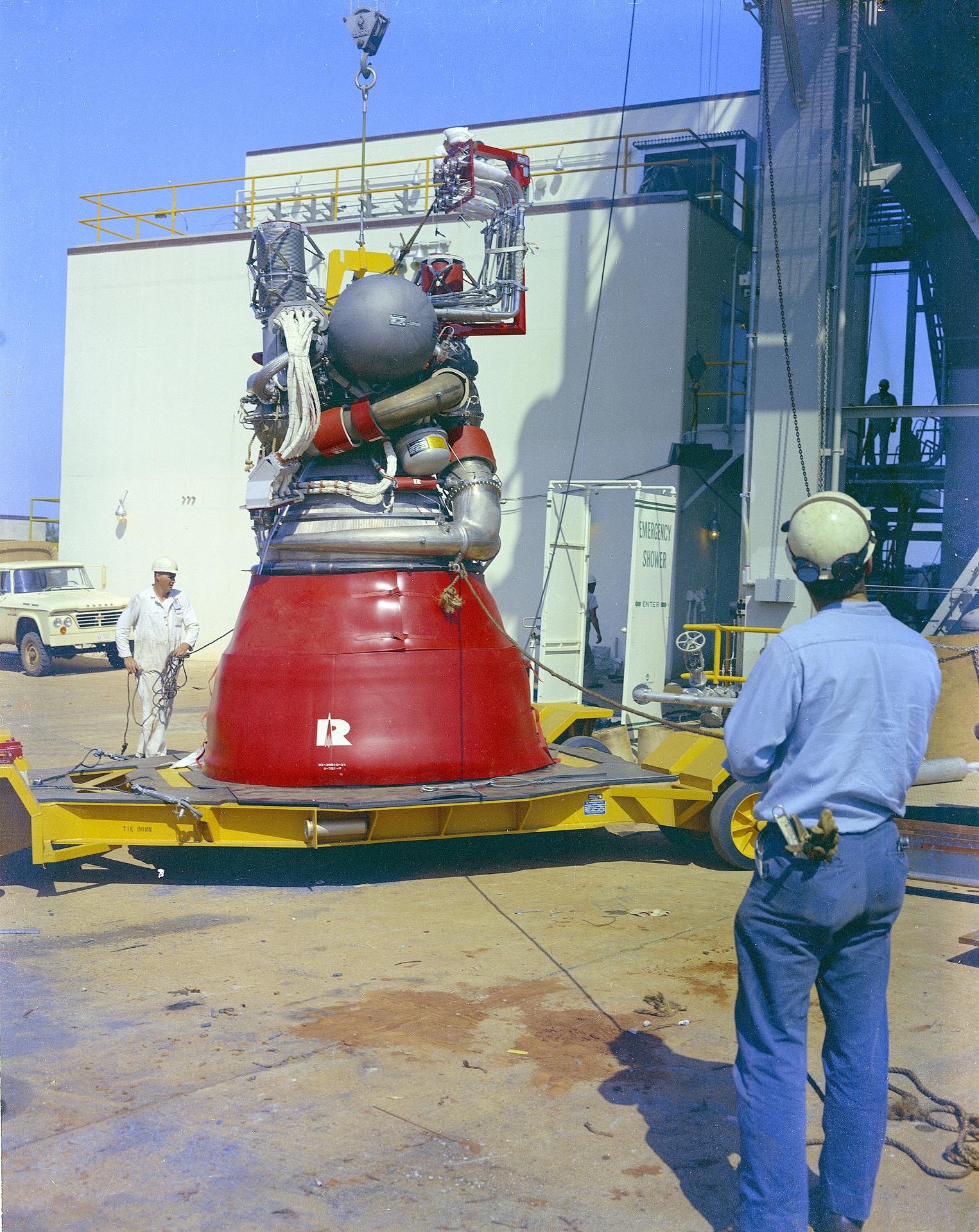 A J-2 engine is lifted into a test stand