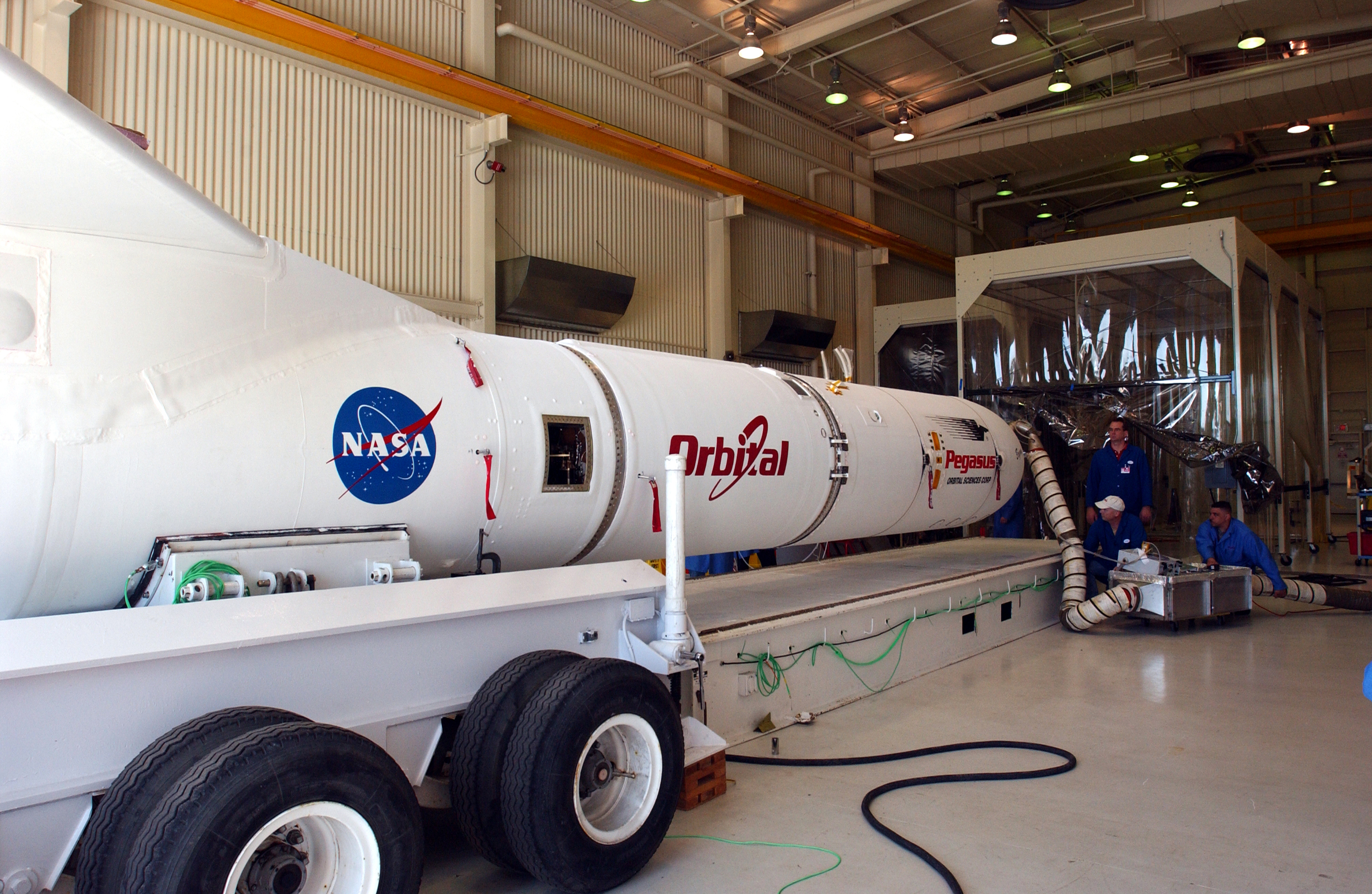 Il complesso del razzo Pegasus XL e della sonda AIM lascia l'edificio 165