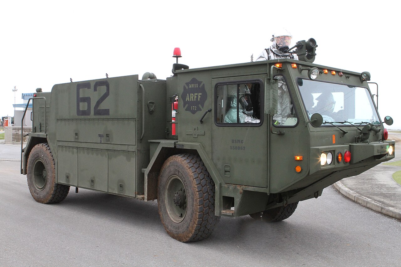 Aircraft rescue and firefighting vehicle during an emergency training exercise on a runway.