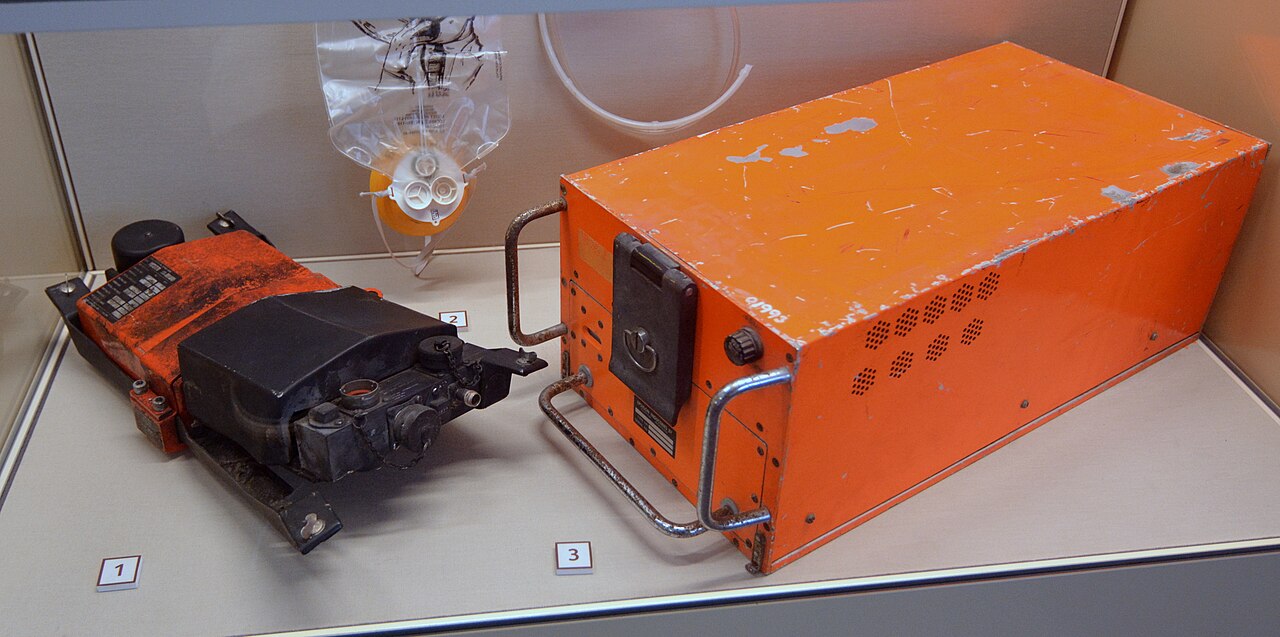 Two flight data recorders displayed in a museum case.