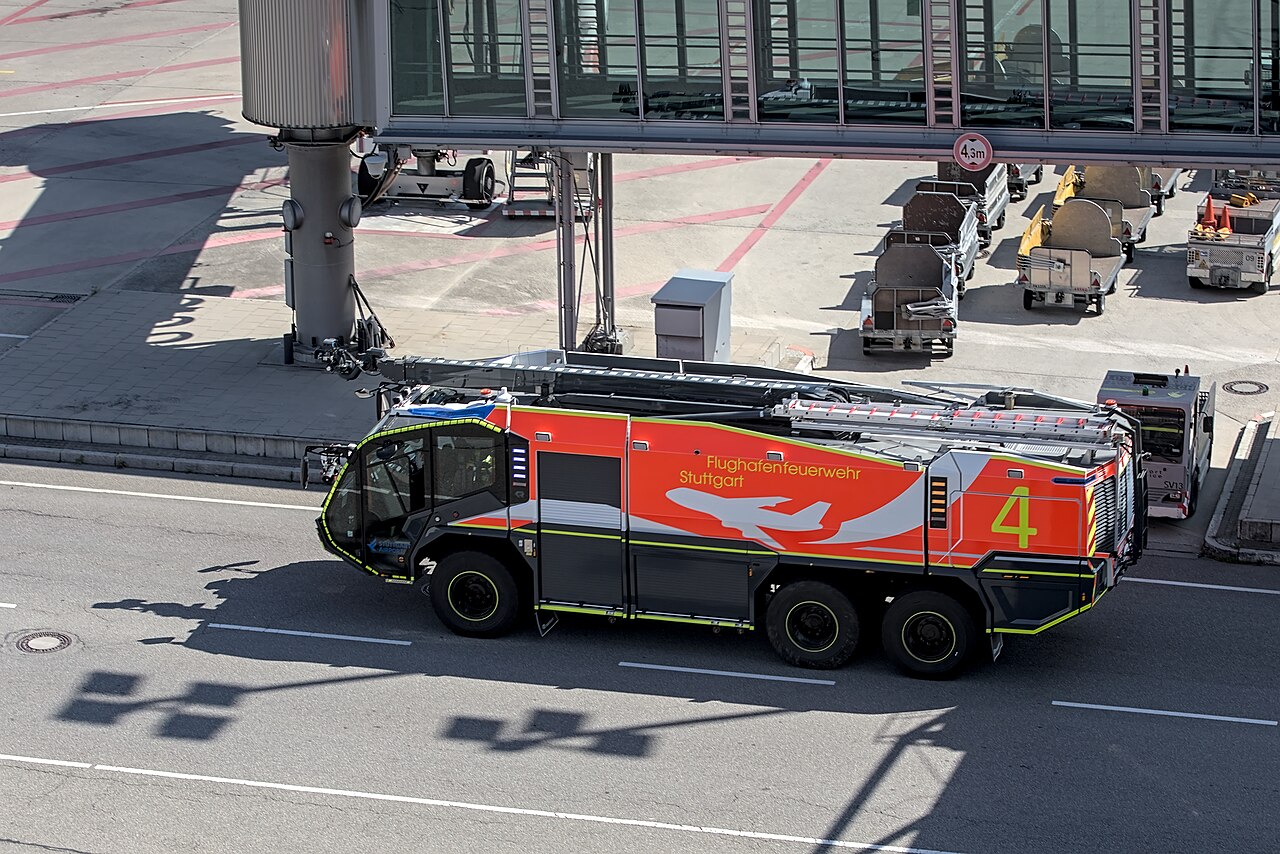 Line-up of German airport crash tenders parked on an apron.