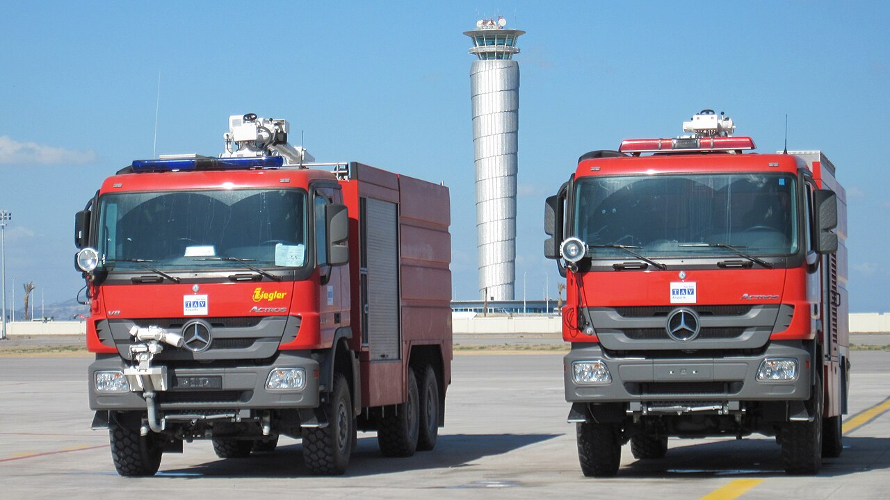 Camion de pompiers SSLIA stationné sur l'aire de trafic d'un aéroport.