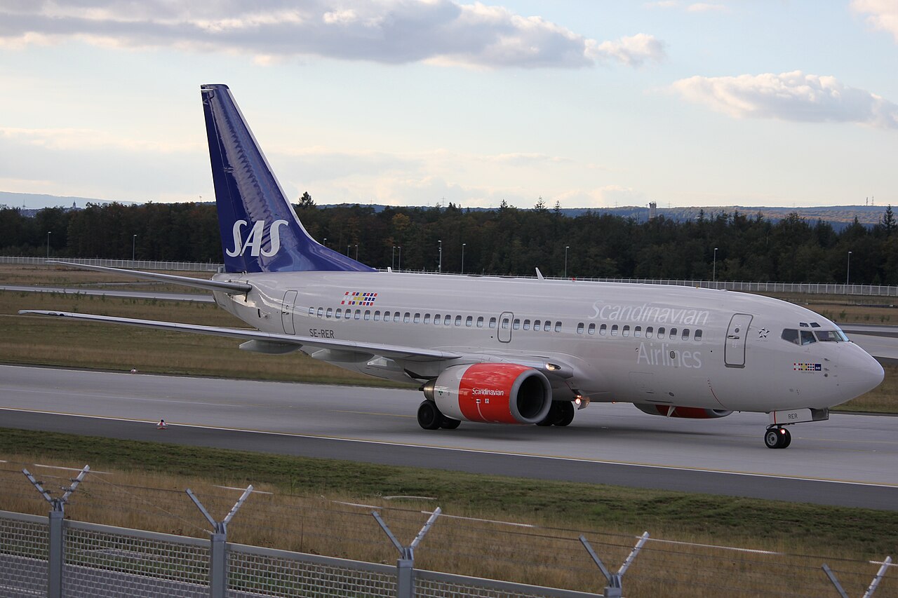 SAS Boeing 737-700 taxiing next to the north-west runway at Frankfurt Airport.