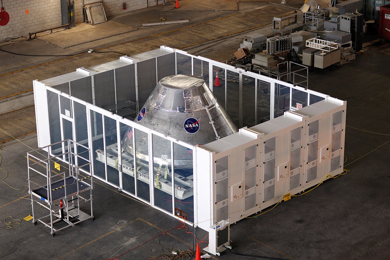 Space capsule inside a temporary clean room set up in the assembly building.