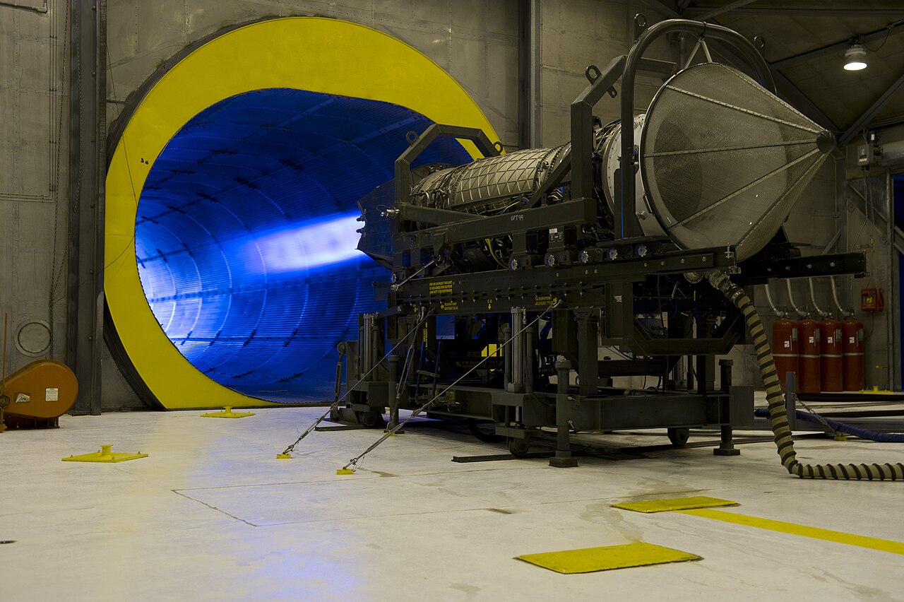 Jet engine on a test stand running in full afterburner inside a sound-suppressing test cell.