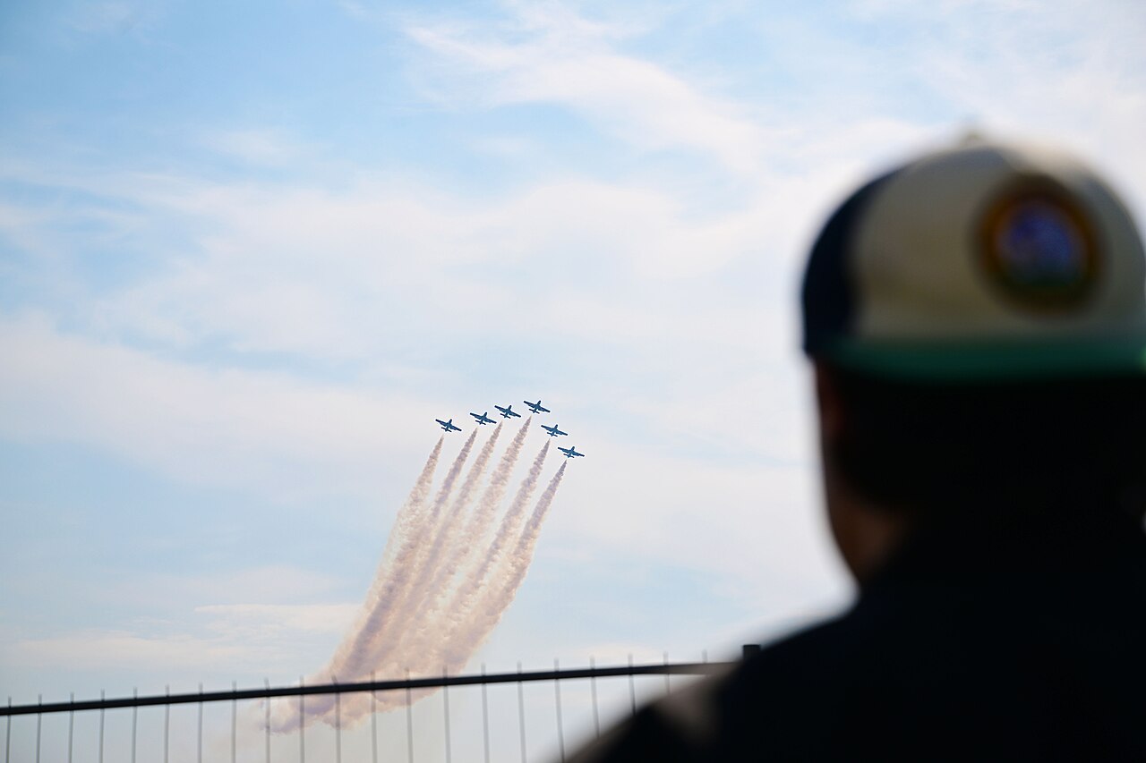 The Frecce Tricolori aerobatic team flies in formation trailing smoke.