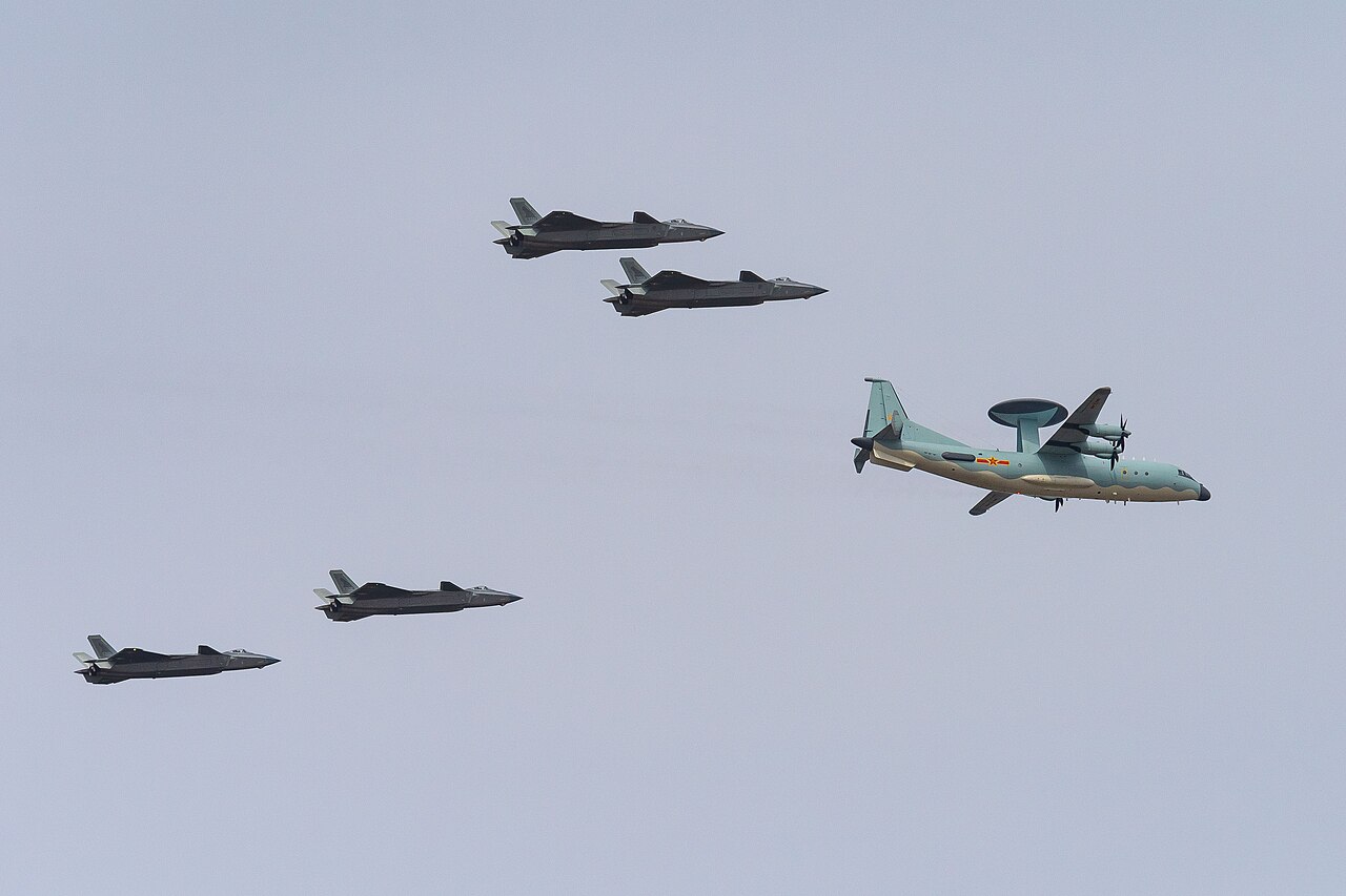An airborne early warning aircraft leads a formation of J-20 fighters at an air show.