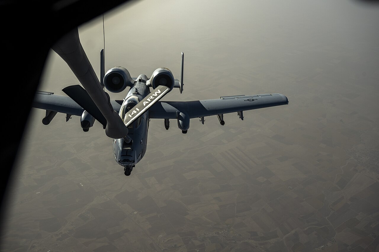 A KC-135 tanker refuels an A-10 Thunderbolt II attack aircraft in flight.