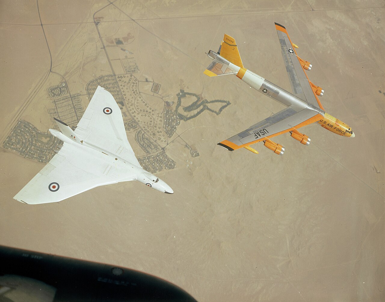 An Avro Vulcan bomber flies alongside a B-52 in a historic photograph.