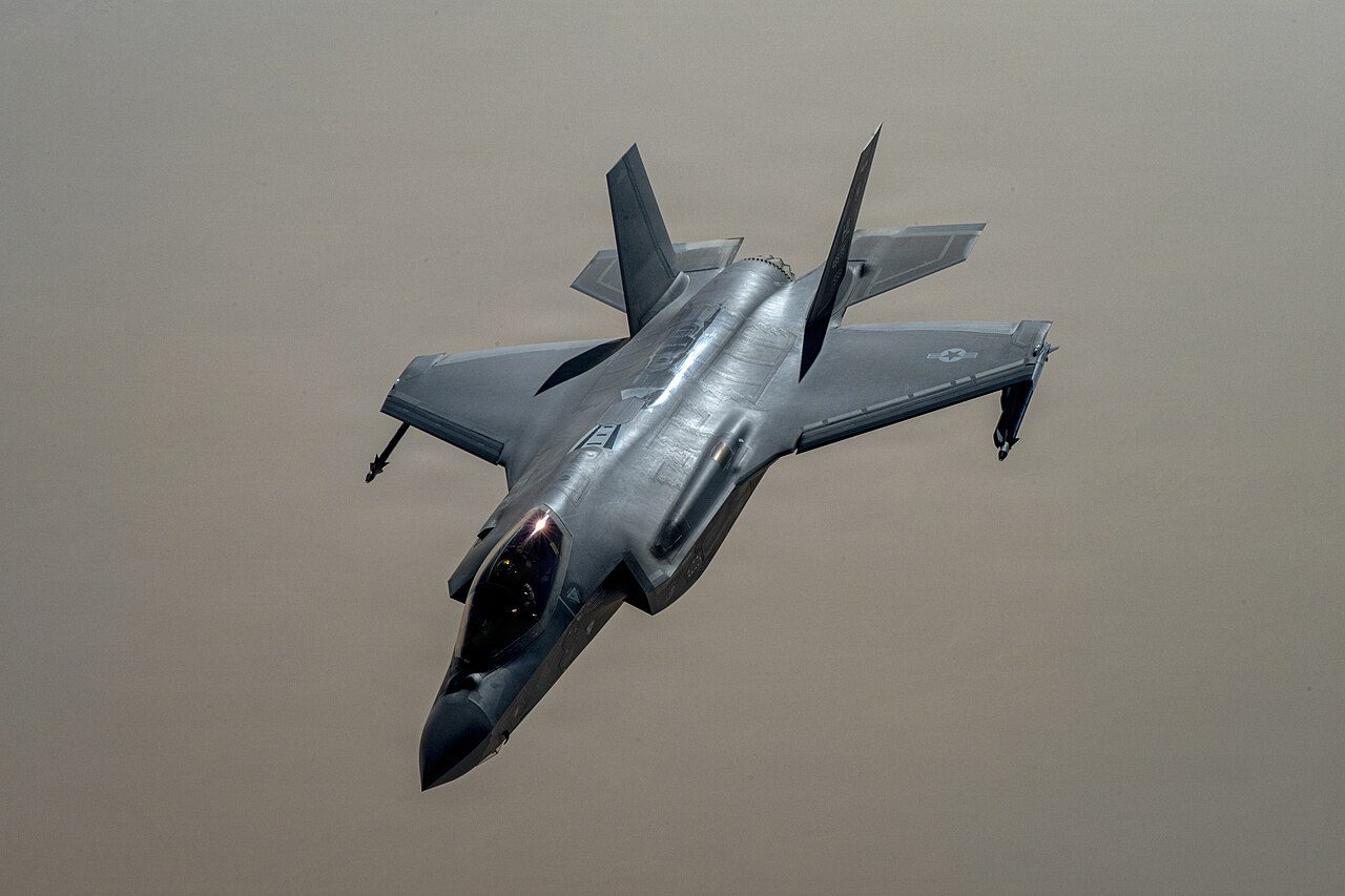 An F-35 Lightning II fighter pulls away from a KC-135 tanker after aerial refuelling.