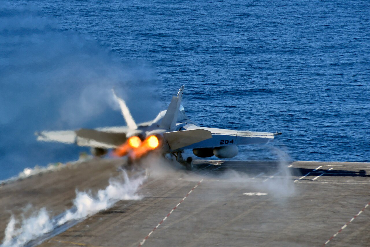 Um caça F/A-18E Super Hornet é catapultado do convés de um porta-aviões.