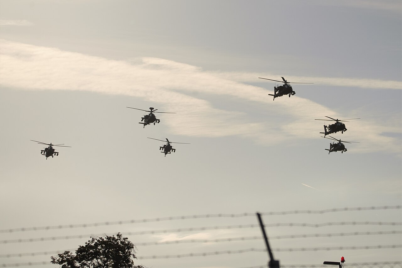 AH-64 Apache attack helicopters fly in formation.