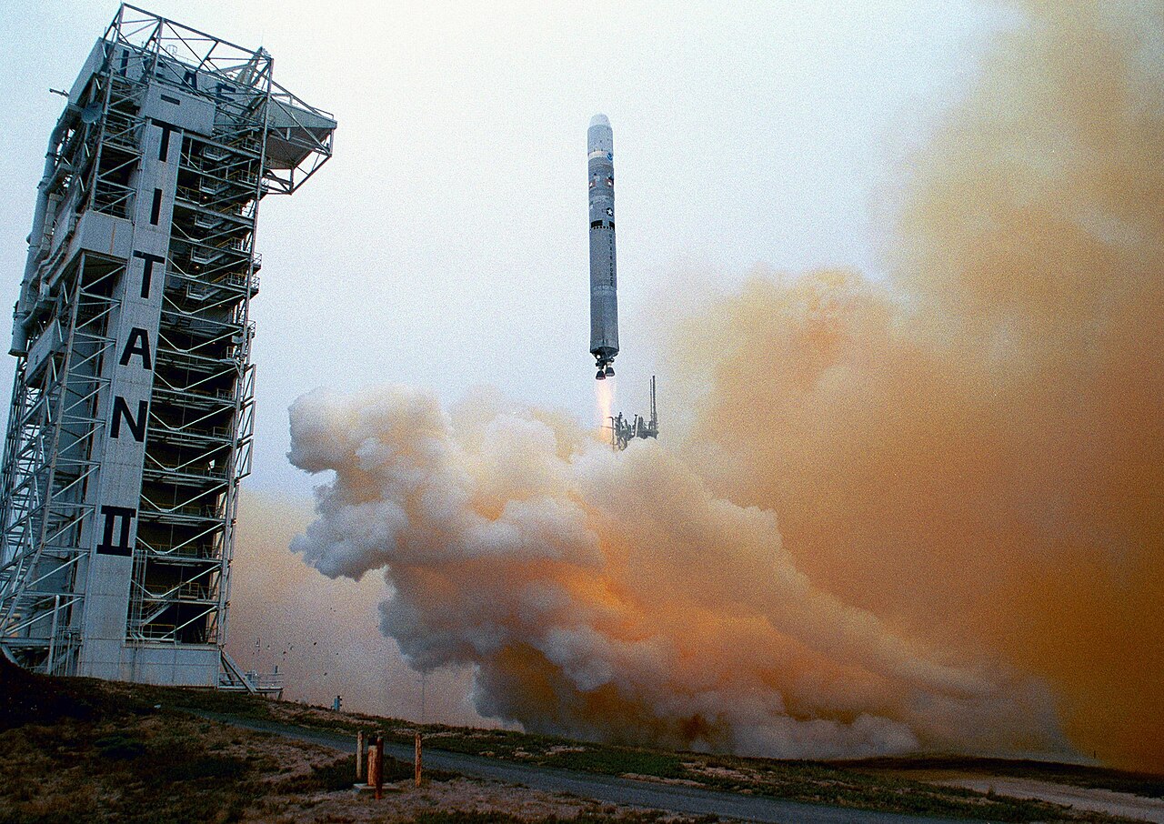 A Titan 23G rocket climbs past the launch tower at Vandenberg Air Force Base.