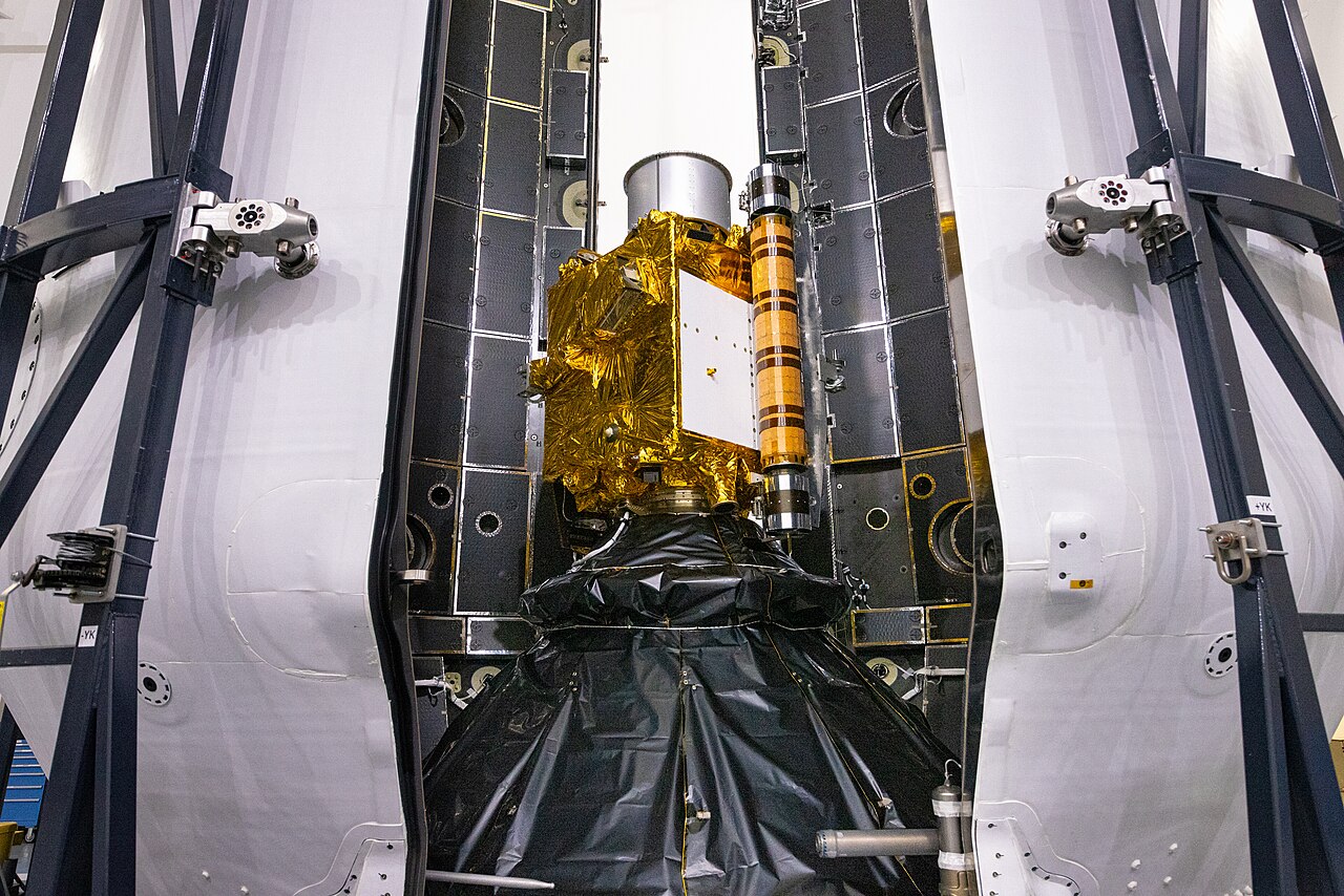 Both halves of a Falcon 9 payload fairing close around the DART spacecraft during encapsulation.