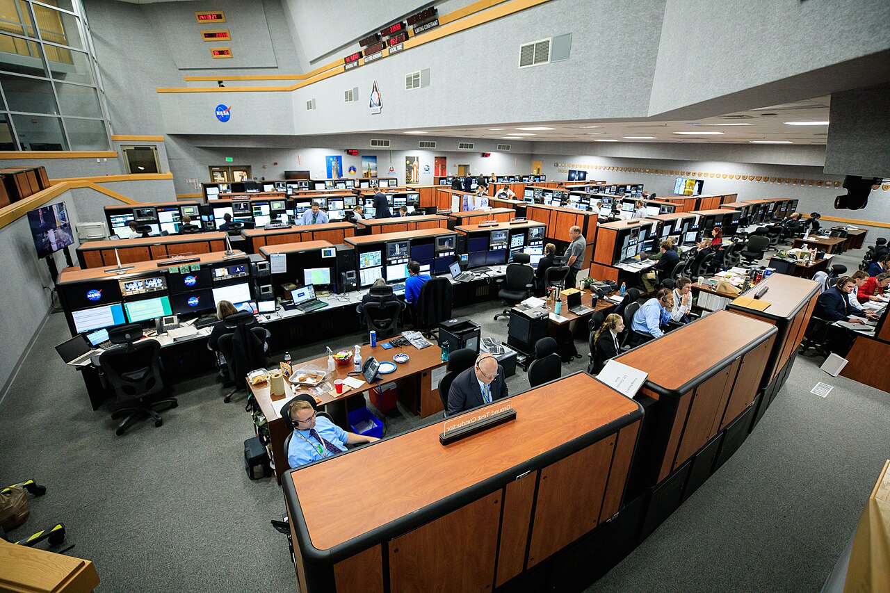 The launch team works at their consoles inside the firing room of the Launch Control Center.