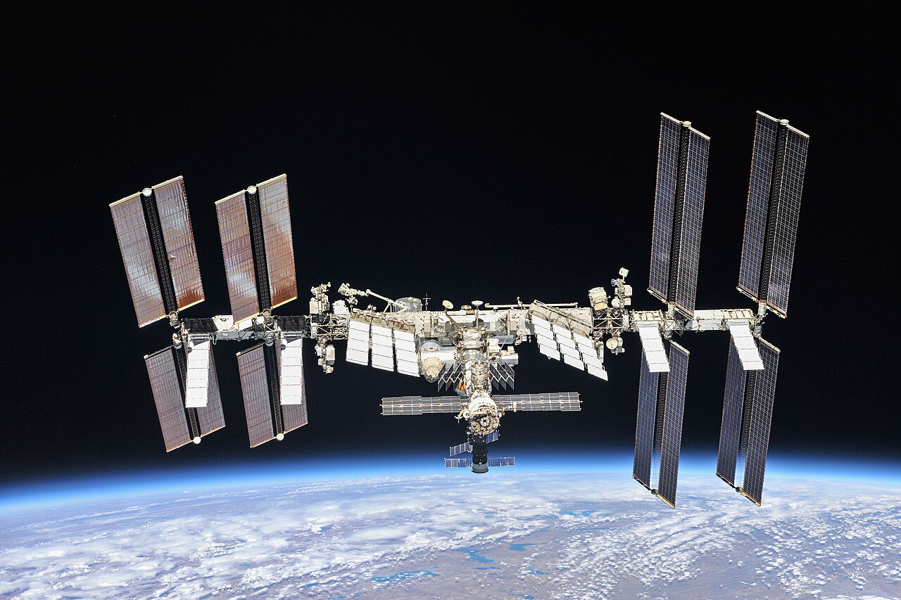 The International Space Station in orbit above Earth seen from a Soyuz spacecraft.