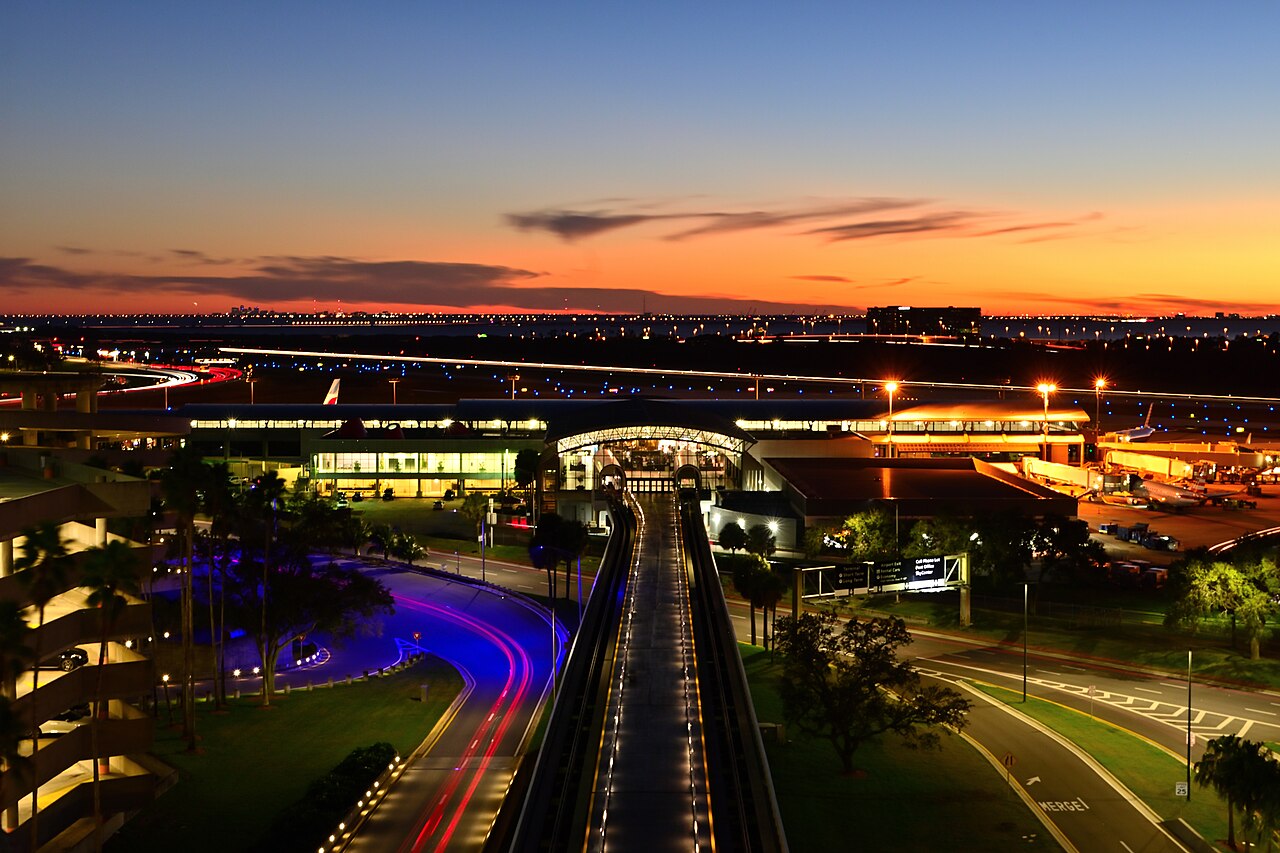 Airport terminal lit at dusk with light trails.