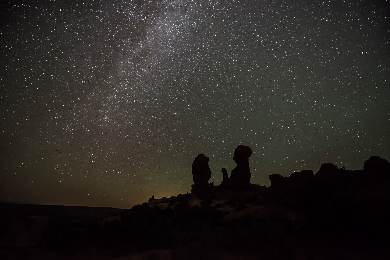 The Milky Way over a desert rock landscape.