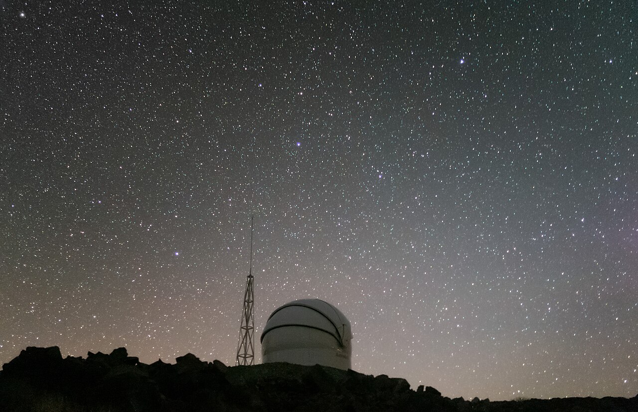 Open observatory dome against a starry sky.