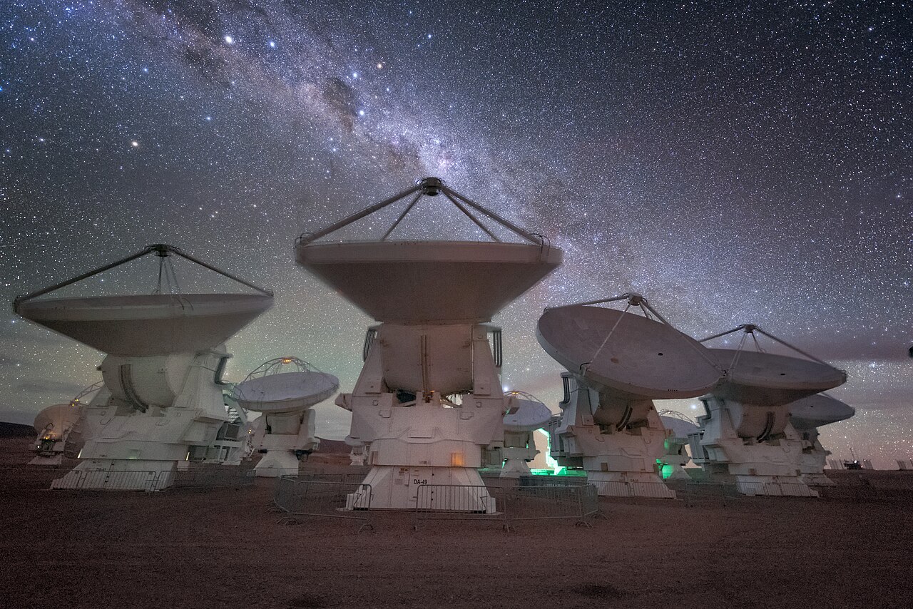 Radio telescope antennas pointing at the sky on a high plateau.