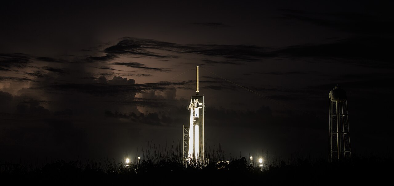 Rocket on the launch pad against a stormy night sky.