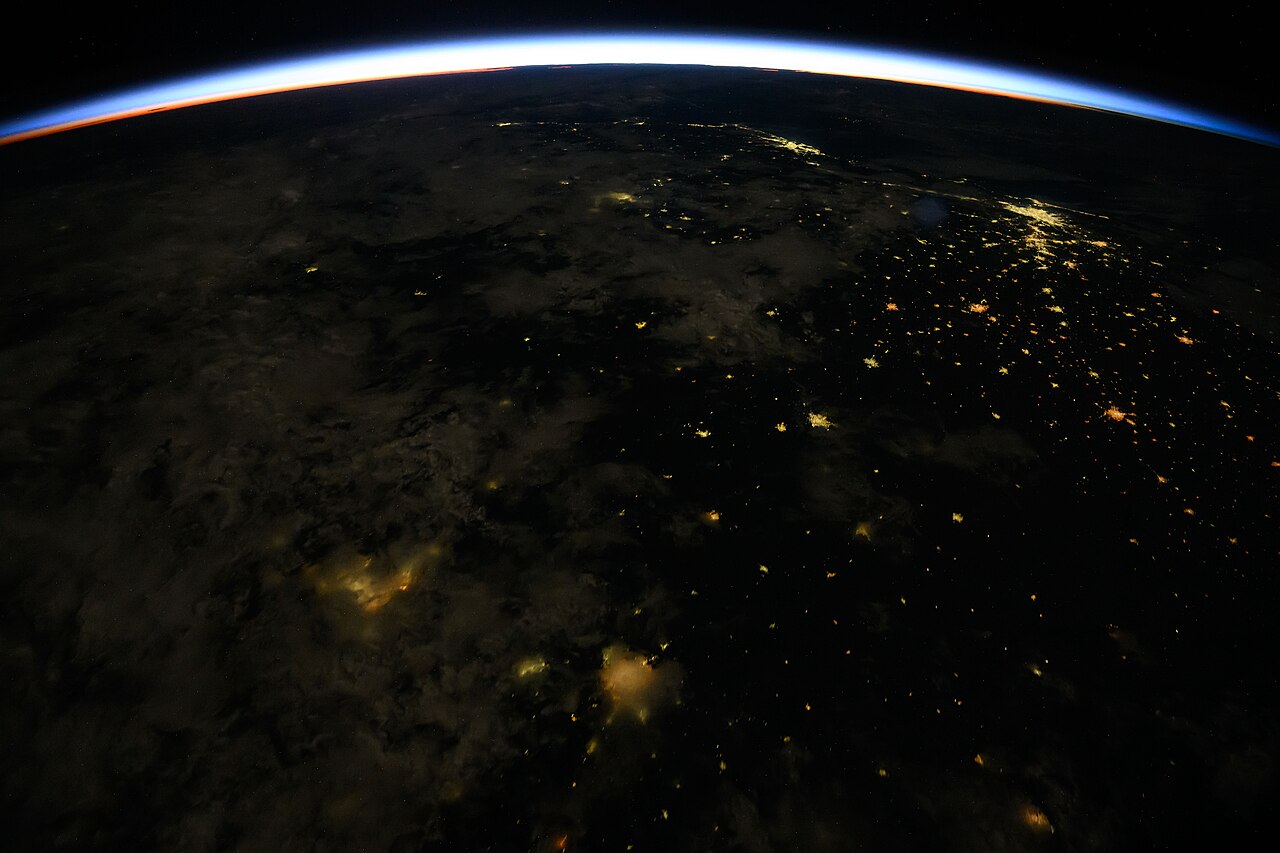 Orbital sunrise over the curved horizon of Earth.