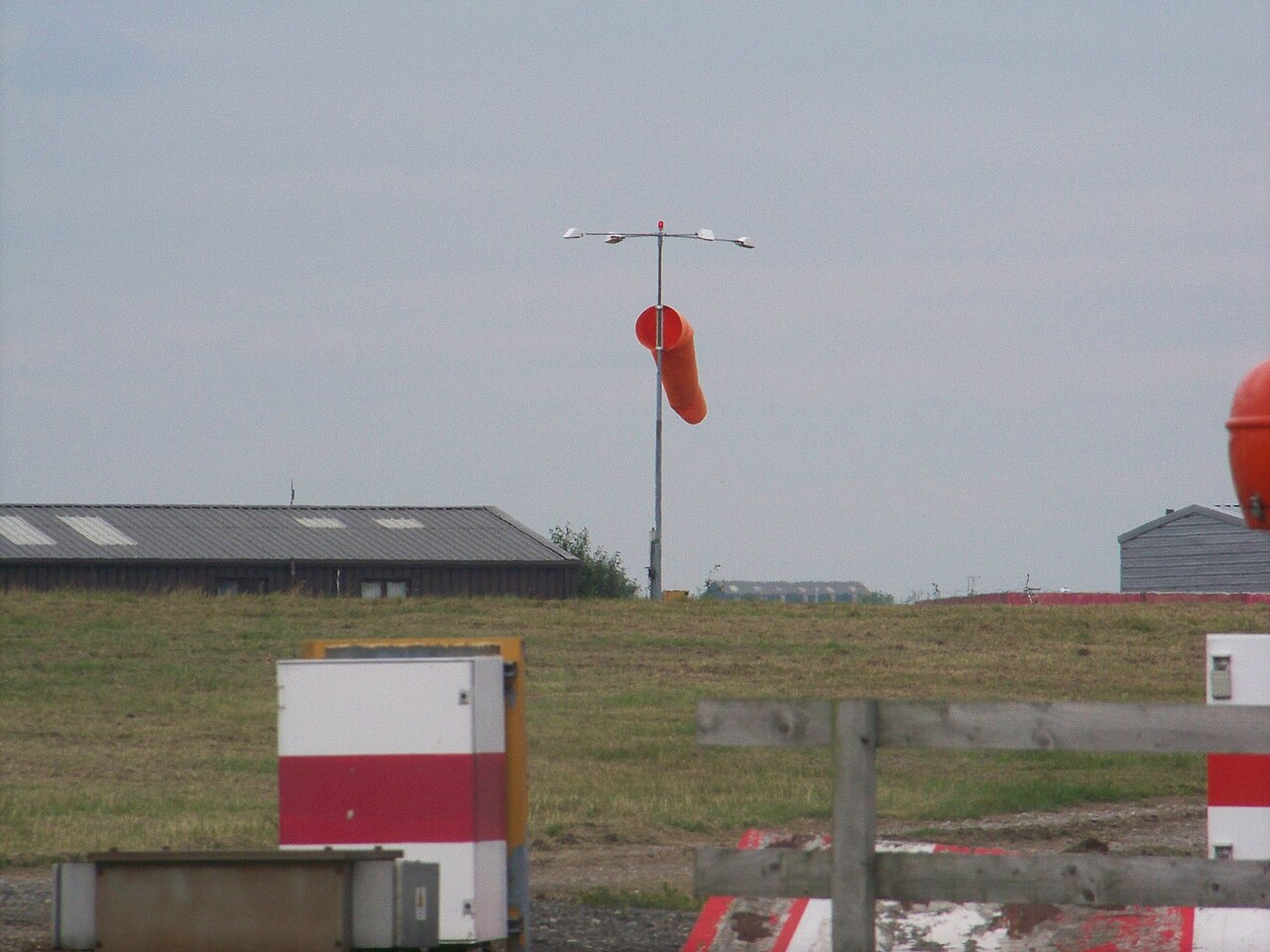 Airport windsock under a cloudy sky.