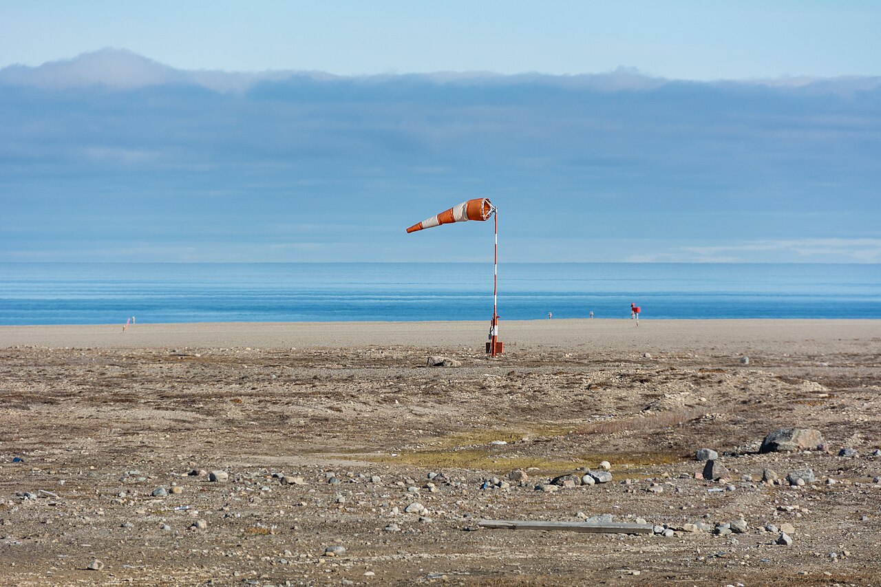 Orange airfield windsock streaming against the sky.